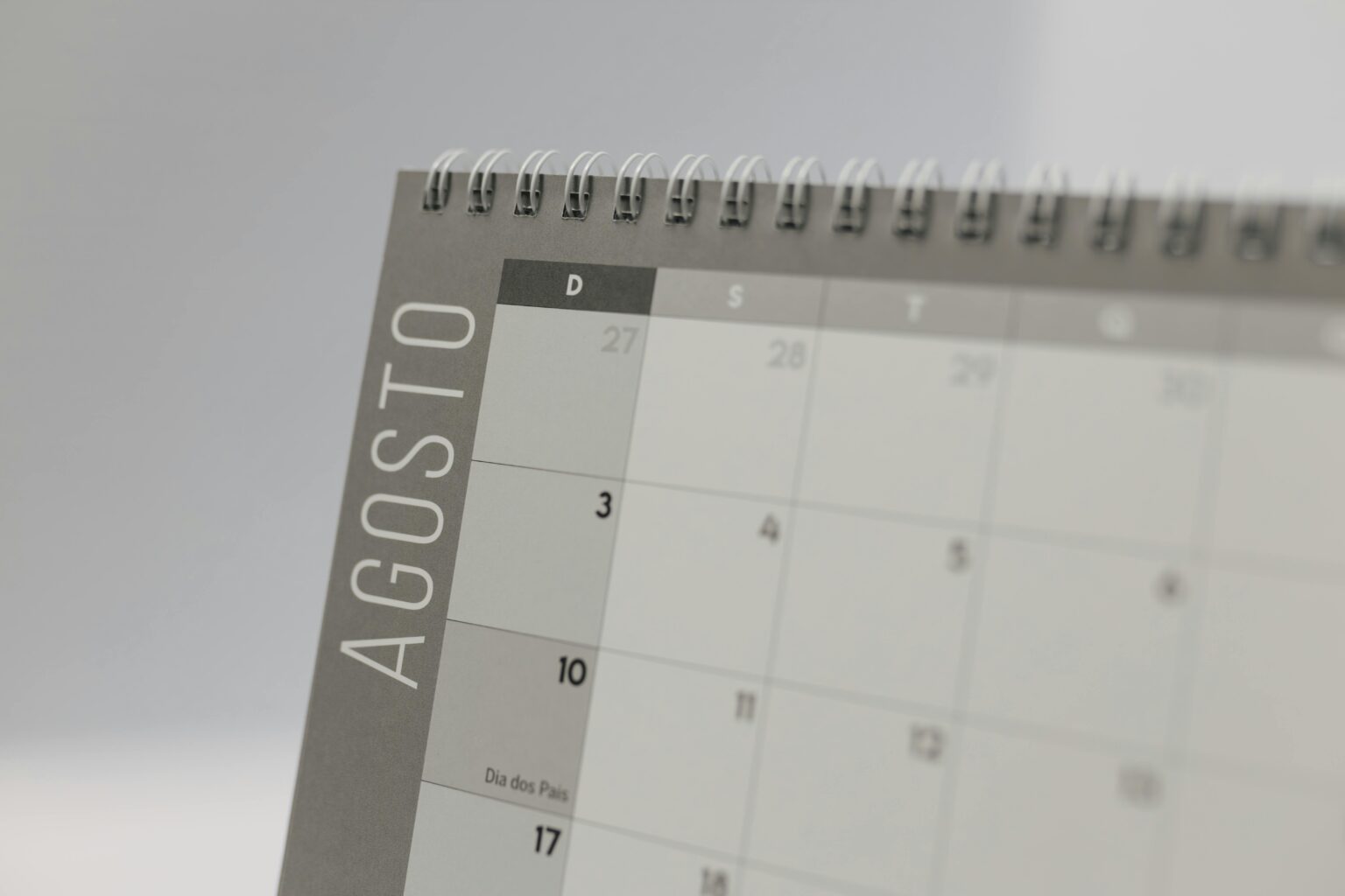 Detailed close-up of a spiral-bound calendar displaying the month of August.